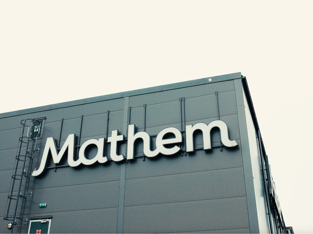 En byggnad med Mathems logotyp